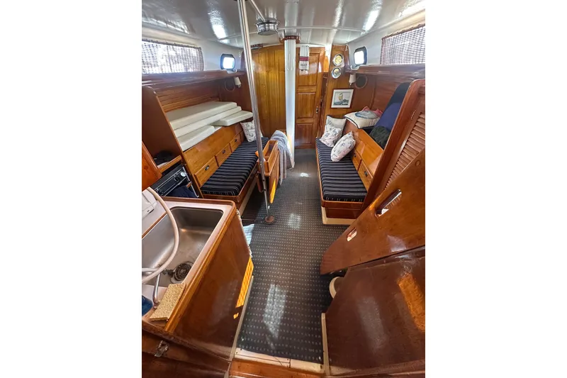 Slide: The Image of Interior of a 1966 CAL Cal 48 sailboat with wooden furnishings and cozy seating. - 7