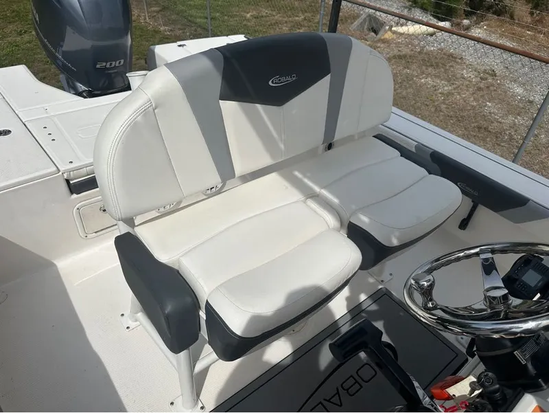 Slide: The Image of Interior of 2023 Robalo 226 Caymen with white seating and helm. - 10