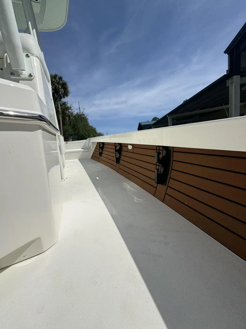 Slide: The Image of Pathfinder 2500 Hybrid 2026 boat deck with wood paneling, sunny sky. - 22
