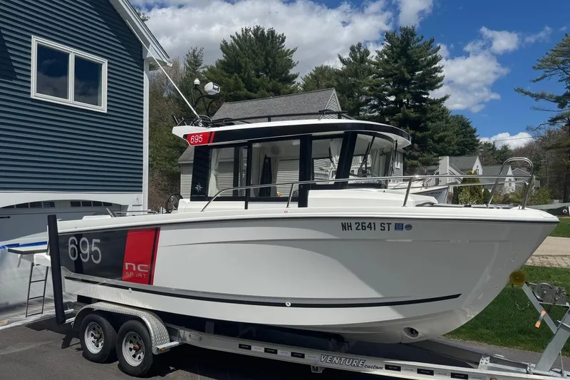 Slide: The Image of 2023 Jeanneau NC Sport 695 Series 2 boat on trailer, parked near house. - 1