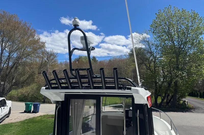 Slide: The Image of 2023 Jeanneau NC Sport 695 Series 2 boat with rod holders and radar, parked outdoors. - 11