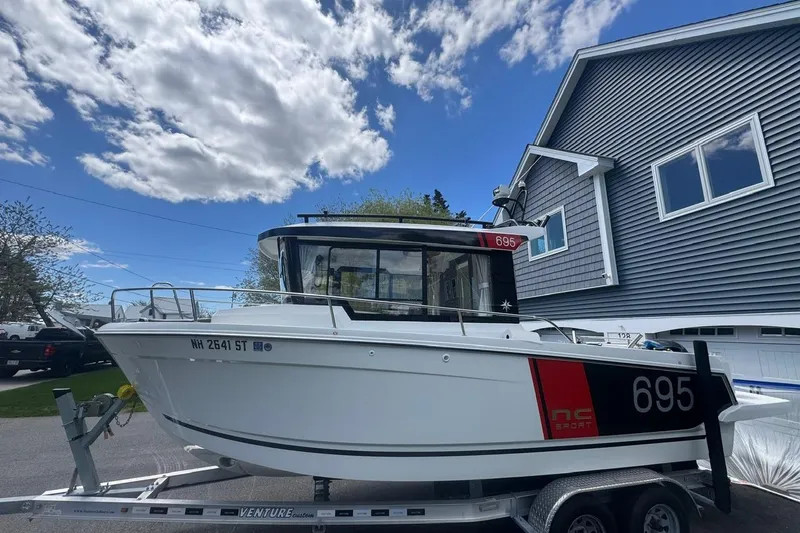 Slide: The Image of 2023 Jeanneau NC Sport 695 Series 2 boat on trailer, parked near a house. - 12