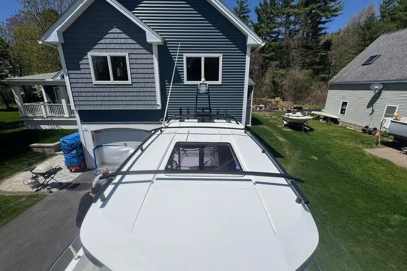 Slide: The Image of 2023 Jeanneau NC Sport 695 Series 2 boat parked in a residential driveway. - 13