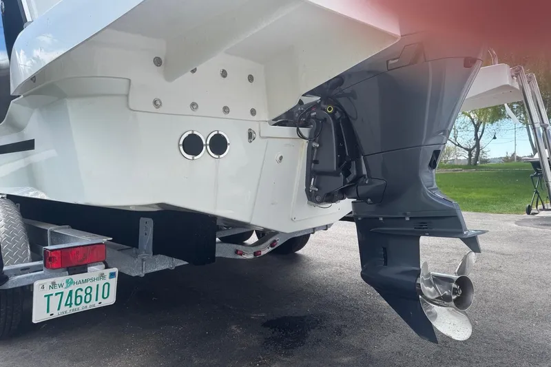Slide: The Image of 2023 Jeanneau NC Sport 695 Series 2 boat on trailer, showcasing outboard motor and hull details. - 14