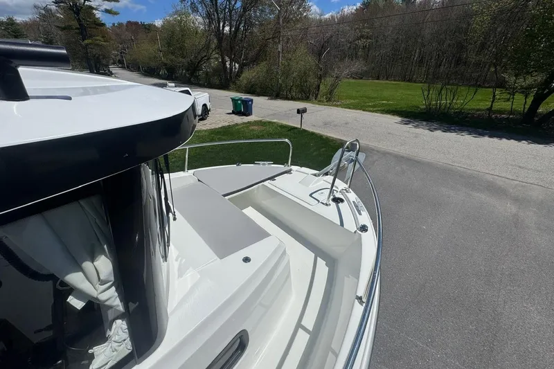 Slide: The Image of 2023 Jeanneau NC Sport 695 Series 2 boat parked on a driveway, surrounded by trees. - 16