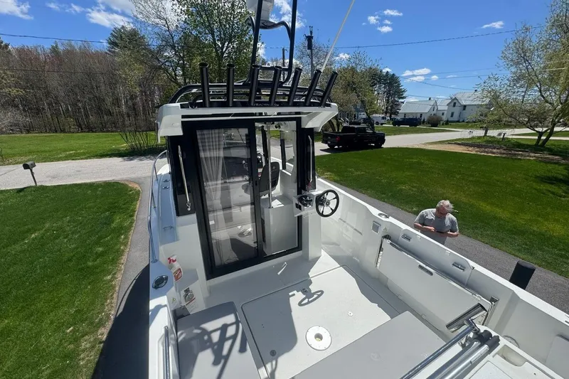 Slide: The Image of 2023 Jeanneau NC Sport 695 Series 2 boat, exterior view, parked on driveway under clear sky. - 19