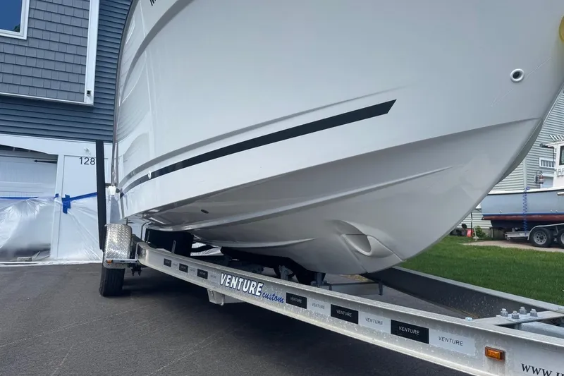 Slide: The Image of 2023 Jeanneau NC Sport 695 Series 2 boat on trailer, parked near a house. - 3