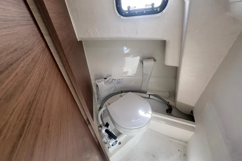 Slide: The Image of 2023 Jeanneau NC Sport 695 Series 2 boat bathroom with compact toilet and window. - 30