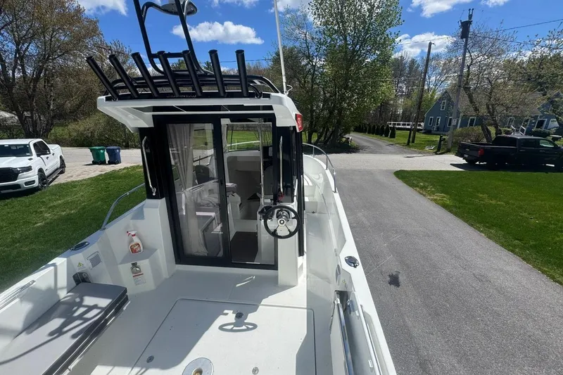 Slide: The Image of 2023 Jeanneau NC Sport 695 Series 2 boat, docked on a sunny day, showcasing its sleek design. - 6