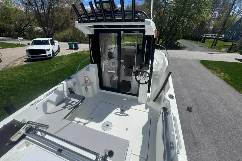 Slide: The Image of 2023 Jeanneau NC Sport 695 Series 2 boat, docked on a driveway, surrounded by greenery. - 7