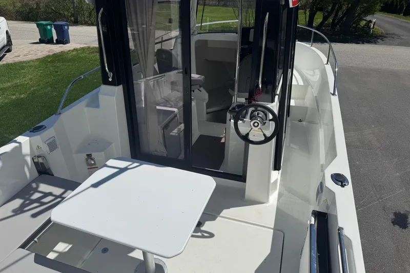 Slide: The Image of 2023 Jeanneau NC Sport 695 Series 2 boat interior with steering wheel and table. - 9