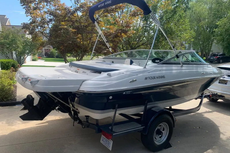 The Image of 2014 Four Winns 190 Horizon boat on trailer, parked in a residential driveway. - 0