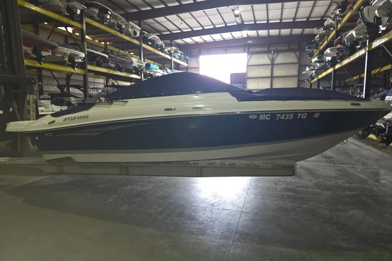 Slide: The Image of 2014 Four Winns 190 Horizon boat stored indoors on a rack. - 11