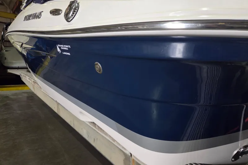 Slide: The Image of 2014 Four Winns 190 Horizon boat with sleek blue and white exterior in marina. - 12