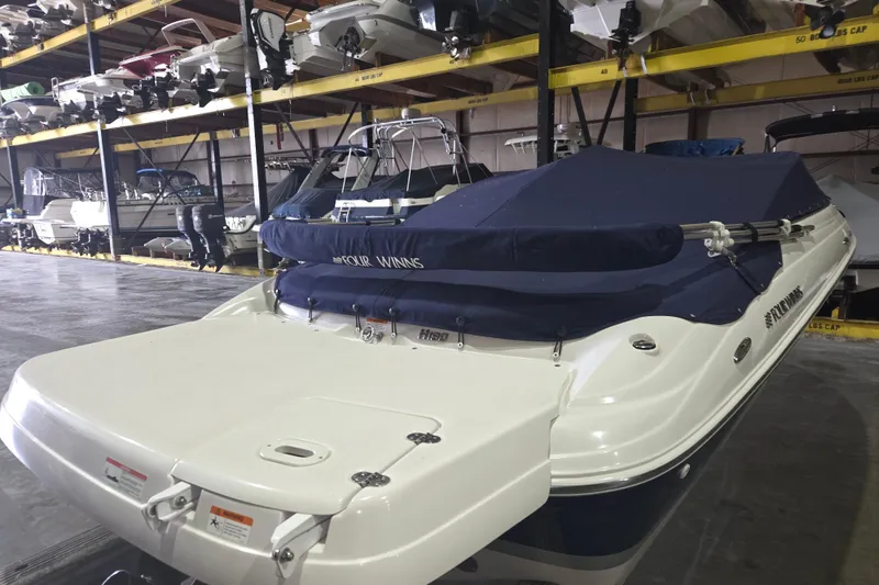 Slide: The Image of 2014 Four Winns 190 Horizon boat in storage, covered with a blue tarp. - 13