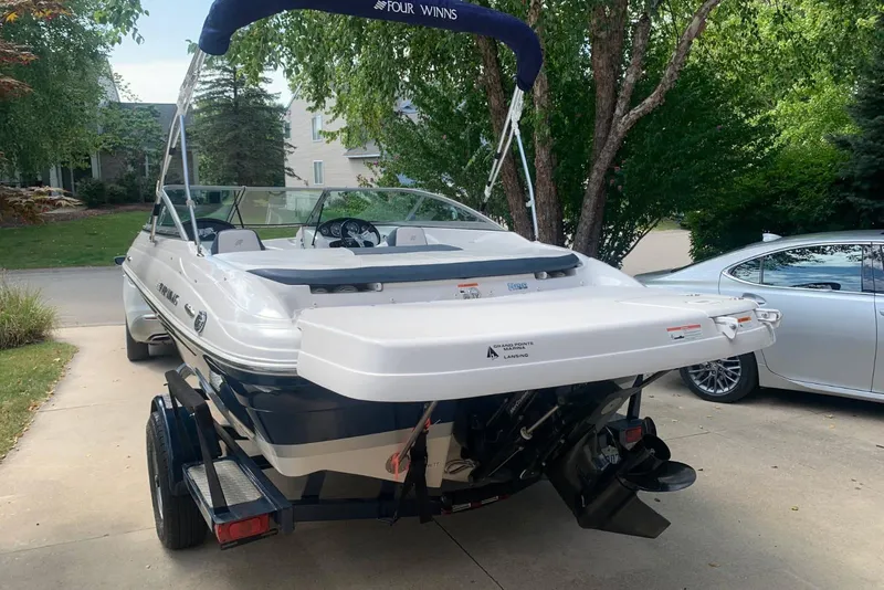 Slide: The Image of 2014 Four Winns 190 Horizon boat on trailer, parked in a driveway. - 14