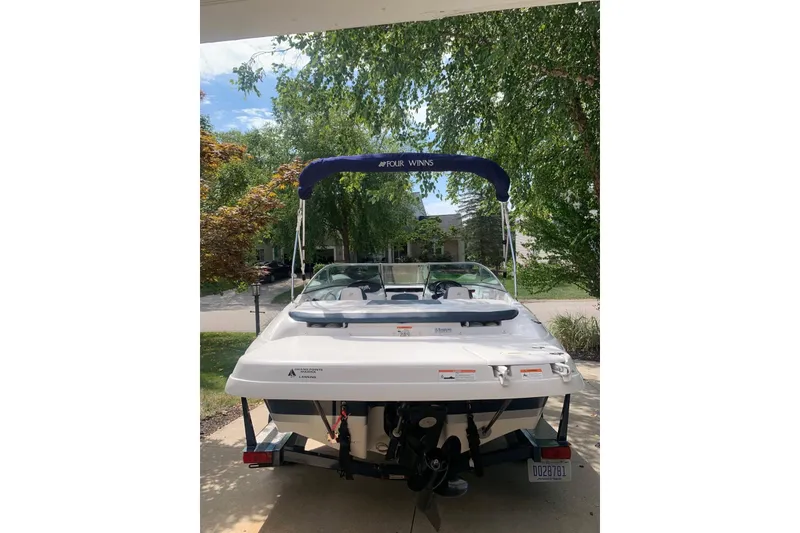 Slide: The Image of 2014 Four Winns 190 Horizon boat with canopy, parked in a driveway. - 15