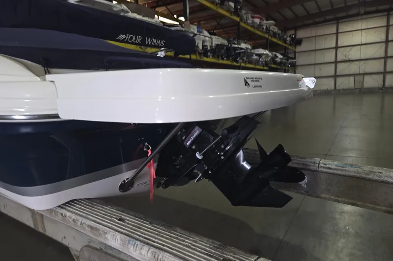 Slide: The Image of 2014 Four Winns 190 Horizon boat in storage, showcasing rear and propeller details. - 7
