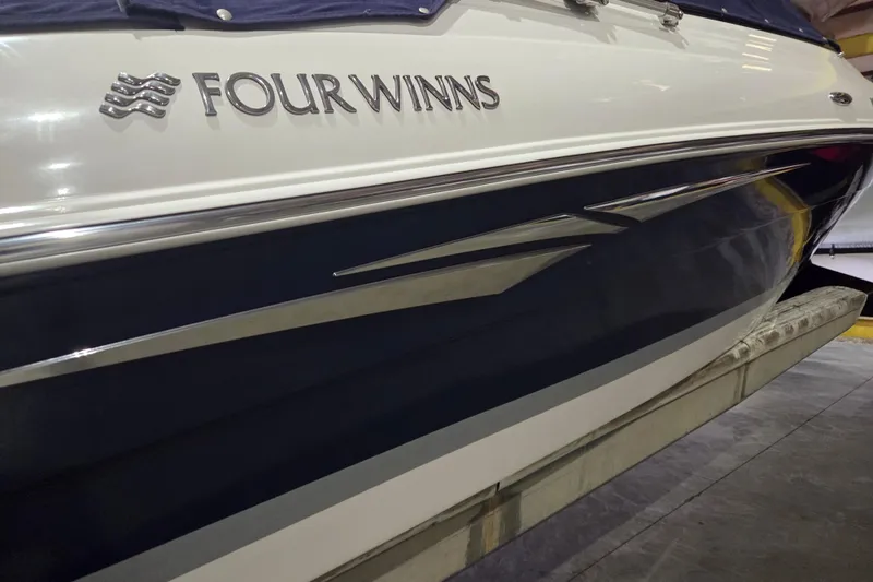 Slide: The Image of 2014 Four Winns 190 Horizon boat side view with logo and sleek design. - 9