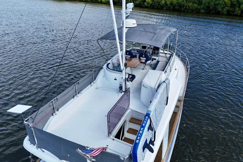 Slide: The Image of 2020 Beneteau Swift Trawler 44 on water, featuring spacious deck and canopy. - 10