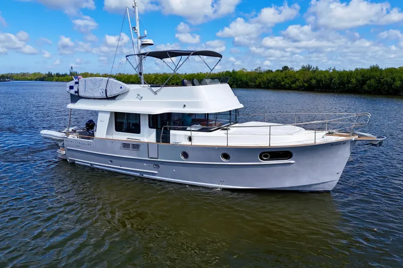 Slide: The Image of 2020 Beneteau Swift Trawler 44 cruising on a calm river under a blue sky. - 15