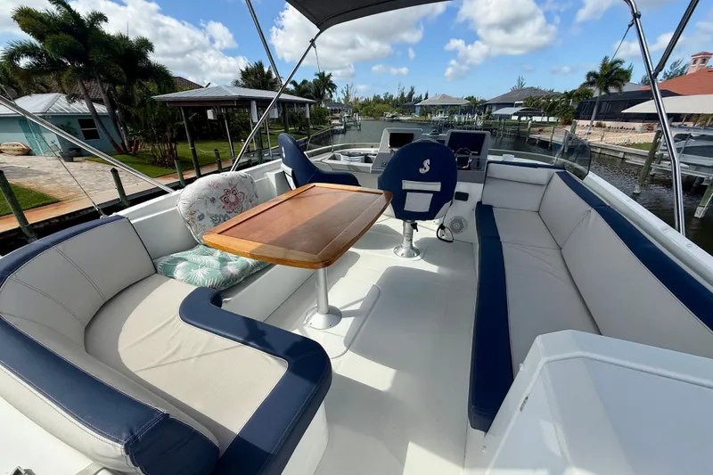 Slide: The Image of Flybridge of 2020 Beneteau Swift Trawler 44 with seating and helm, docked by waterfront homes. - 26