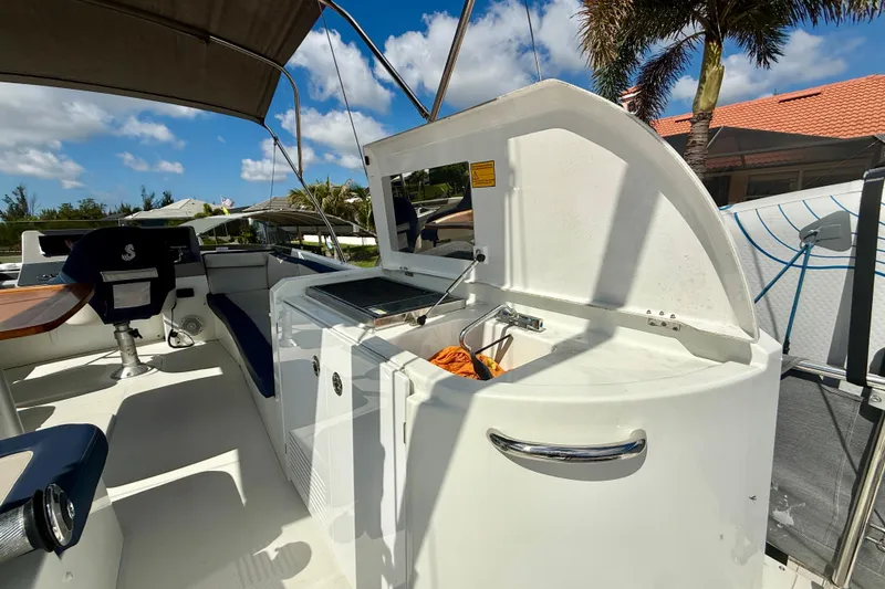 Slide: The Image of 2020 Beneteau Swift Trawler 44 deck with seating and outdoor kitchen under sunny skies. - 27