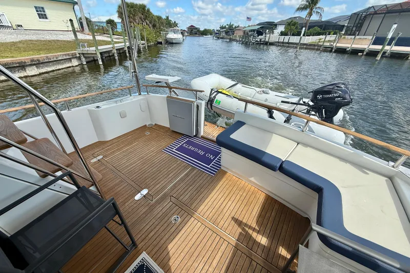 Slide: The Image of Beneteau Swift Trawler 44, 2020 model, featuring a spacious deck with seating and scenic canal view. - 29
