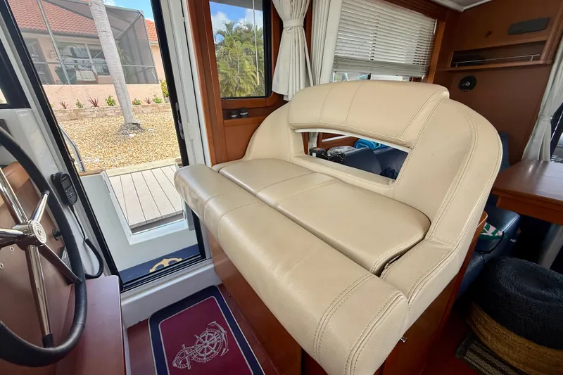 Slide: The Image of Interior of 2020 Beneteau Swift Trawler 44 with beige seating and steering wheel. - 40
