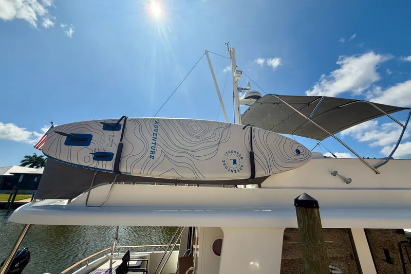 Slide: The Image of Beneteau Swift Trawler 44 (2020) with paddleboard, under sunny blue sky. - 46