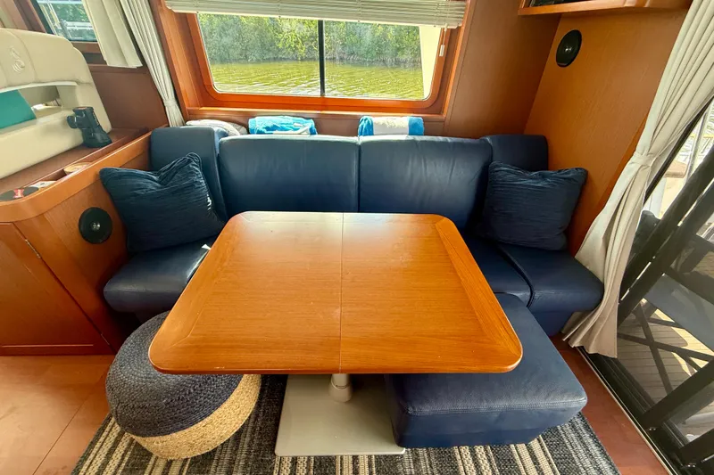 Slide: The Image of Interior of 2020 Beneteau Swift Trawler 44 with blue seating and wooden table. - 48