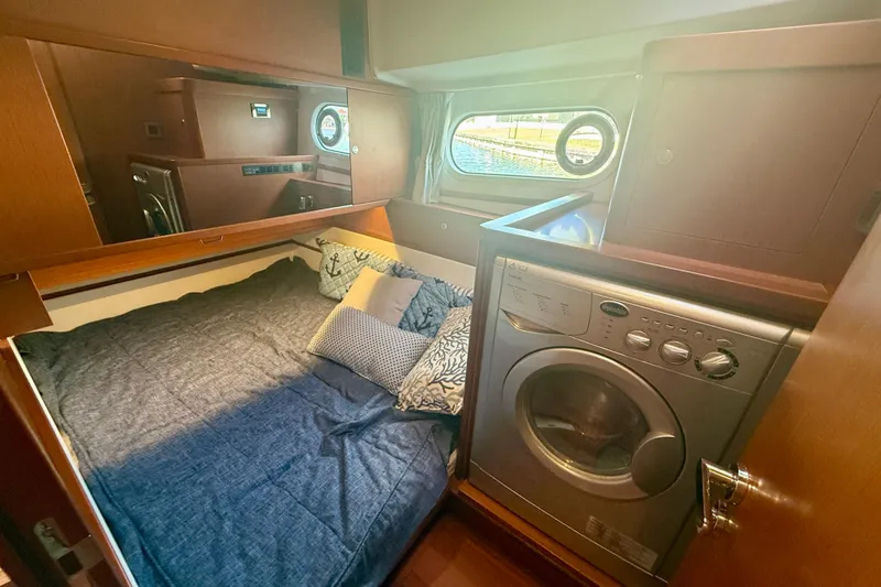 Slide: The Image of Cozy cabin interior of 2020 Beneteau Swift Trawler 44 with bed and washing machine. - 54