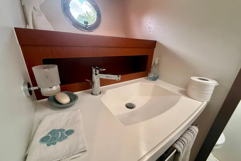 Slide: The Image of Bathroom sink area on a 2020 Beneteau Swift Trawler 44, featuring modern fixtures and accessories. - 56