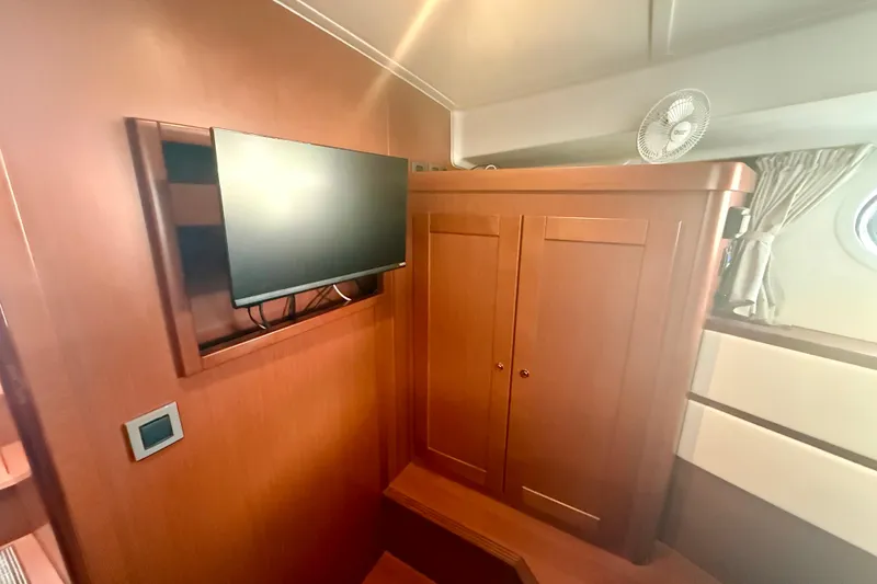 Slide: The Image of Interior of 2020 Beneteau Swift Trawler 44 with TV and wooden cabinetry. - 59