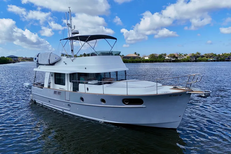 Slide: The Image of 2020 Beneteau Swift Trawler 44 on calm water under a blue sky. - 6