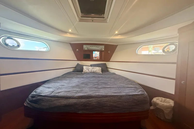 Slide: The Image of Interior cabin of 2020 Beneteau Swift Trawler 44 with cozy bed and porthole windows. - 61