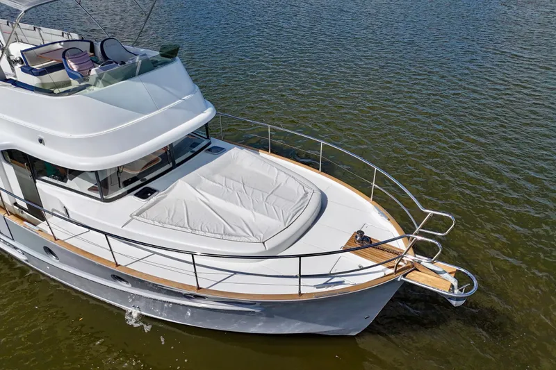 Slide: The Image of 2020 Beneteau Swift Trawler 44 cruising on calm waters, showcasing sleek design and spacious deck. - 9