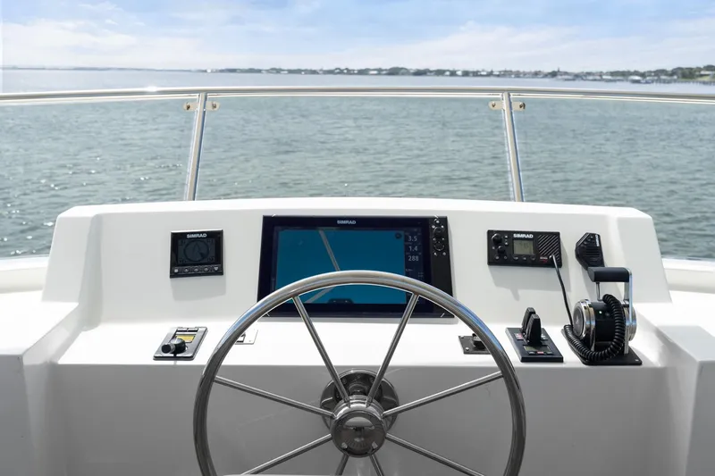 Slide: The Image of Helm of 2022 Alm Trawler Delfino 64 with navigation equipment, steering wheel, and ocean view. - 17