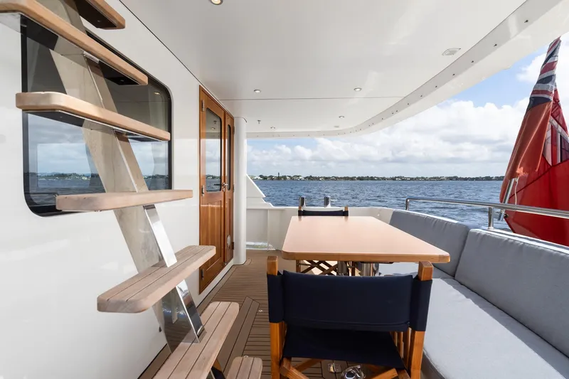 Slide: The Image of Outdoor deck of 2022 Alm Trawler Delfino 64 yacht with seating and table. - 31