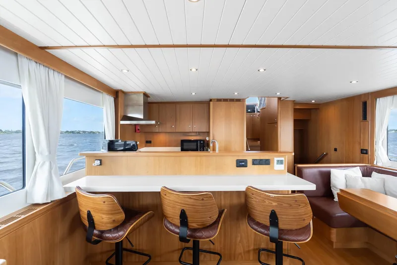 Slide: The Image of Luxurious interior of 2022 Alm Trawler Delfino 64 yacht with modern kitchen and seating area. - 48