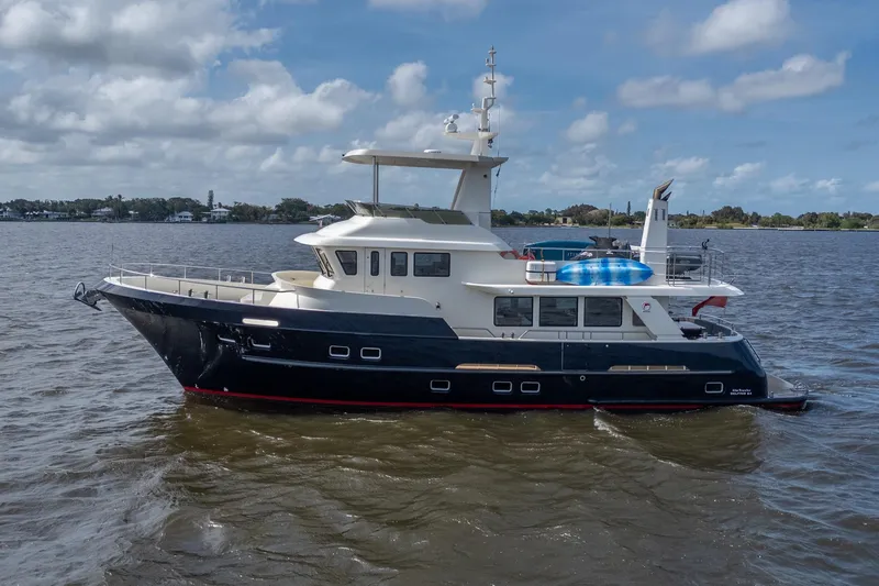 Slide: The Image of 2022 Alm Trawler Delfino 64 by Jachtbouw De Alm cruising on a calm, scenic waterway. - 5