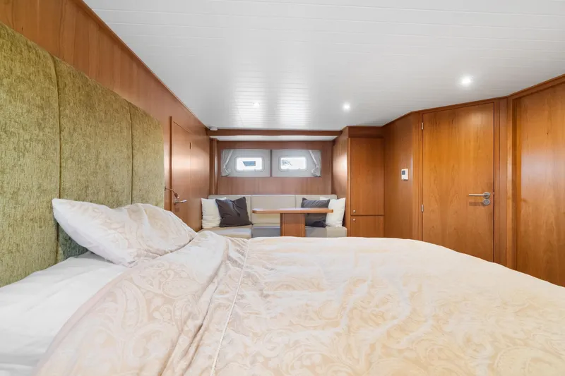 Slide: The Image of Luxurious bedroom interior of 2022 Alm Trawler Delfino 64 yacht, featuring elegant wood paneling. - 54