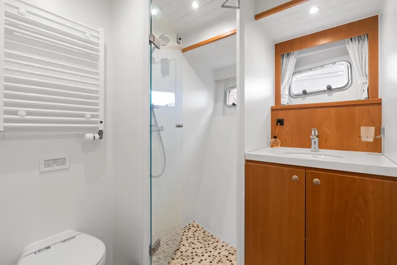 Slide: The Image of Modern bathroom interior of 2022 Alm Trawler Delfino 64 yacht, featuring sleek design and wood accents. - 57