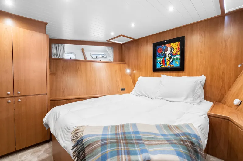 Slide: The Image of Luxurious cabin interior of 2022 Alm Trawler Delfino 64 with cozy bed and artwork. - 58