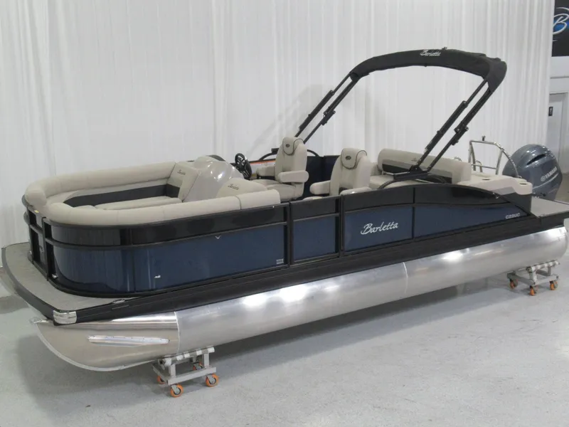 Slide: The Image of A 2020 Barletta C22UC pontoon boat with beige seating and a black Bimini top. - 3