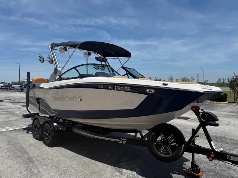 Slide: The Image of 2022 MasterCraft XT22 boat on trailer under sunny skies. - 4
