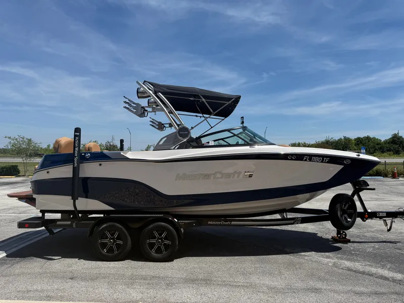 Slide: The Image of 2022 MasterCraft XT22 boat on trailer under blue sky. - 5