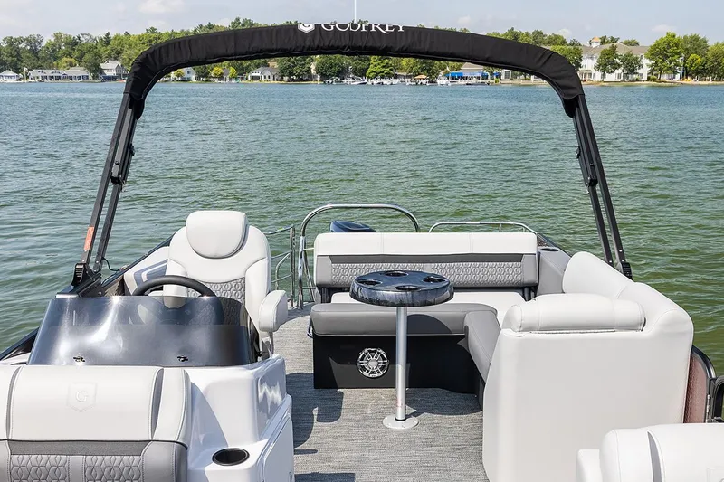 Slide: The Image of Manufacturer Provided Image: 2023 Godfrey SWEETWATER 2486 SFL pontoon boat on a lake with seating and table. - 12