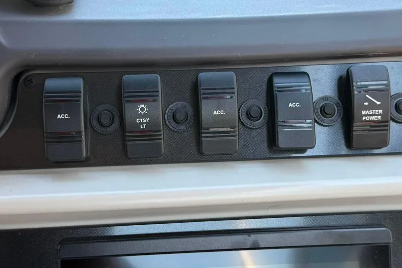 Slide: The Image of Control panel of 2023 Godfrey Sweetwater 2486 SFL with accessory and master power switches. - 28