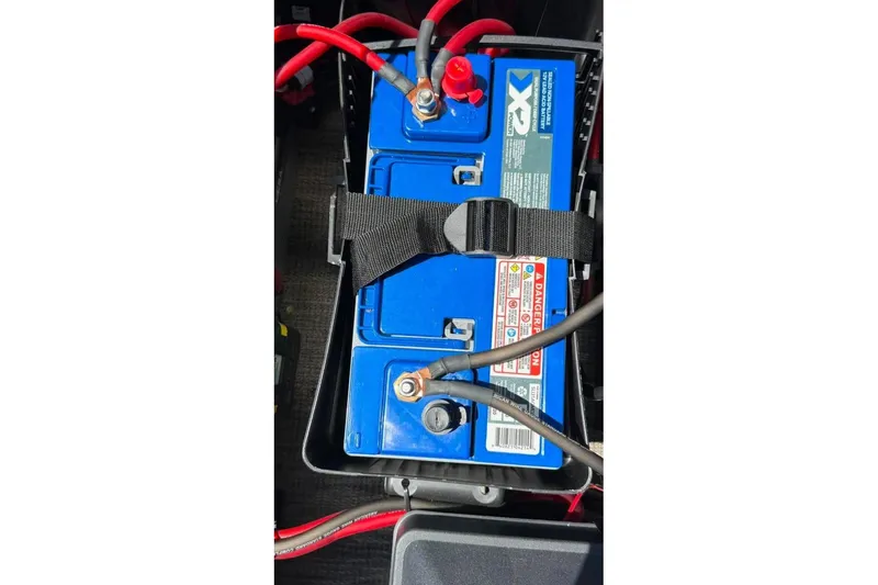 Slide: The Image of Battery setup in a 2023 Godfrey Sweetwater 2486 SFL boat with red and black cables. - 30